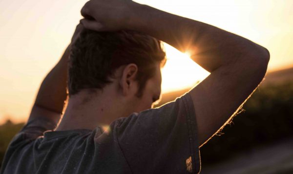 Man grabbing hair in sunset