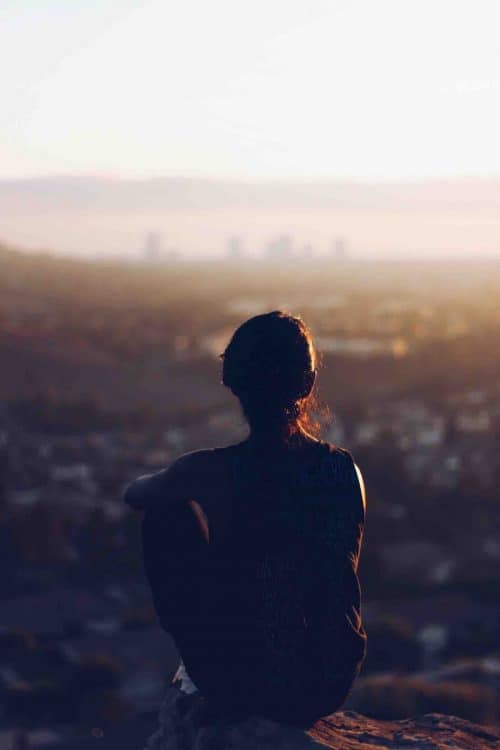 Women looking over city from cliff edge