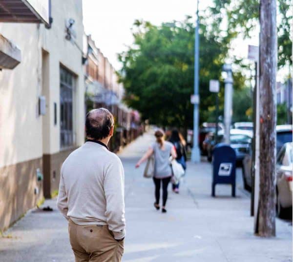 Balding man looking down street