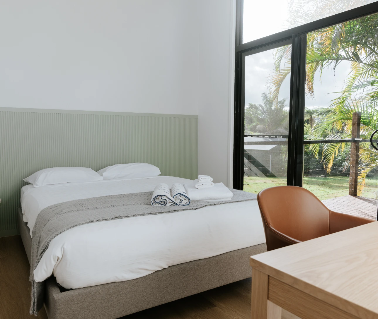 A bedroom and study desk with a view of the grounds